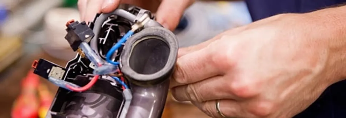 Vacuum repair technician reconnecting wiring and components in Seattle, WA