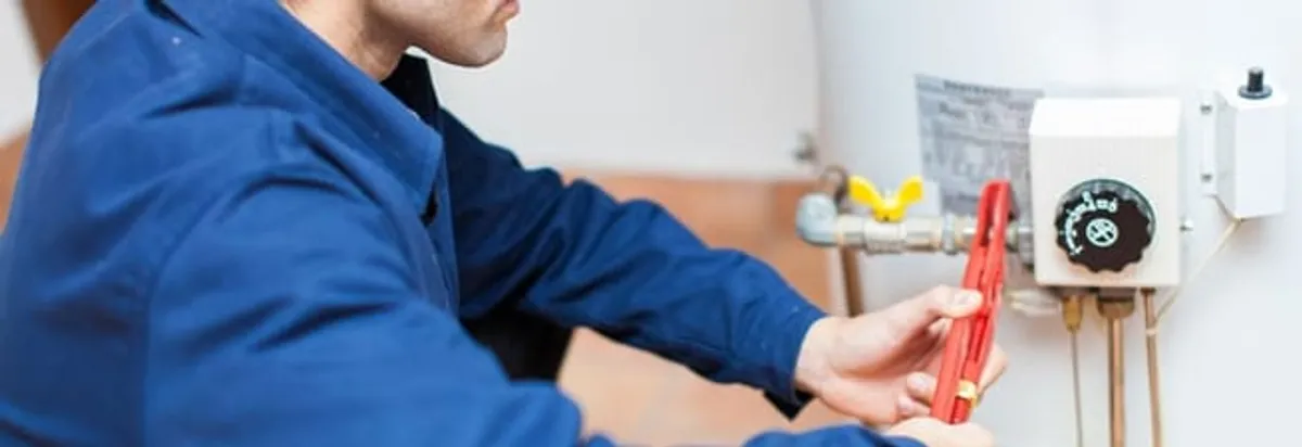 Water heater repair technician adjusting the temperature control and gas valve in Seattle, WA
